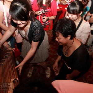 酒会还没开始，大家都在围着一台古筝看