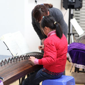 老师在帮助学生调整正确的手势