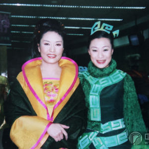 2002年中央电视台春节联欢晚会上，女子十二乐坊与著名女高音歌唱家彭丽媛合作演出歌曲《谢谢你 朋友》。(图为周健楠与彭丽媛)